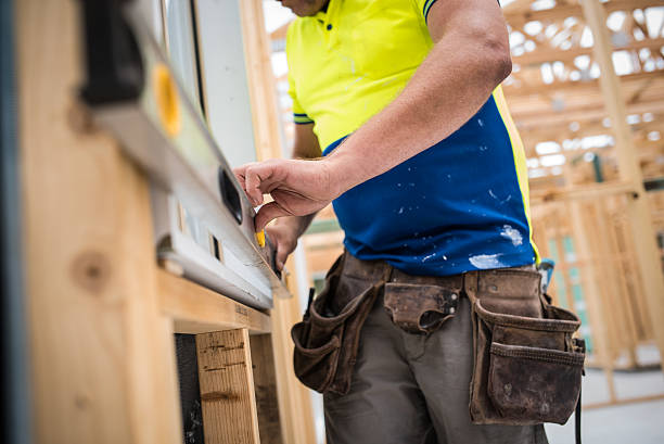 Close up shot of construction worker checking level with water leveler